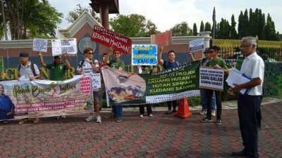 非政府组织代表在霹雳州政府大厦外拉布条反对逾4000公顷森林发展园丘用途。