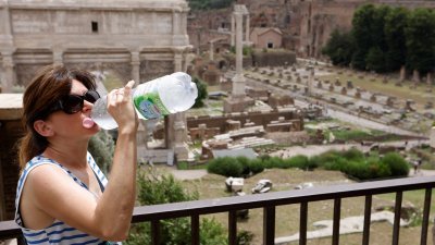 炎热天气下，游客在意大利古罗马广场喝水，避免中暑。（图取自路透社）