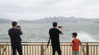 在香港杏花邨海滨，有市民追风观浪。（图取自中通社）
