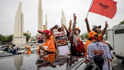 上周日，披塔的支持者开着轿车和摩哆在曼谷市中心示威，途经民主纪念碑时竖起三指礼。（图取自法新社）