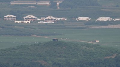 从韩国坡州乌头山统一展望台的方向，能看到朝鲜非军事区一侧的一个村庄和一个军事哨所。（图取自法新社）