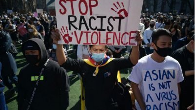 图说：亚裔美国人举著写有“停止种族主义暴力”的标语，参加反对种族主义仇恨的集会。（图取自法新社）