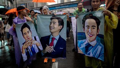 泰国前进党领导人披塔的支持者，周日拿著披塔的画像，冒雨在曼谷示威。（图取自法新社）