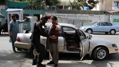 7月6日在阿富汗喀布尔，一名塔利班士兵在检查站检查一名男子。（图取自路透社）