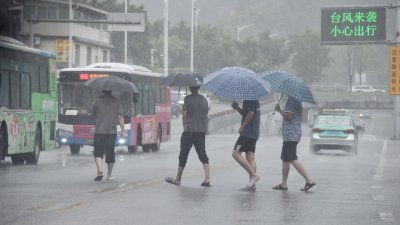 台风“杜苏芮”周五在中国福建晋江沿海登陆。受其影响，福州风雨逐渐加大，民众顶风冒雨出行。（图取自中新社）