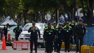 哥伦比亚总统佩特罗的儿子尼古拉斯涉洗钱和不法致富，周六在波哥大被逮捕调查，图为警察走出检察总长办公室。（图取自路透社）