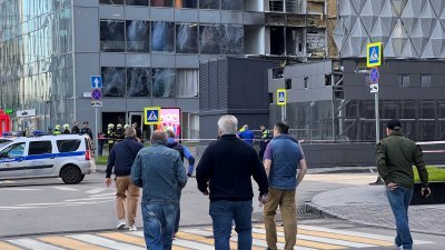 莫斯科周日据报发生乌克兰无人机袭击事件，人们隔天早上在市内一座受损的办公楼附近好奇观察。（图取自路透社）