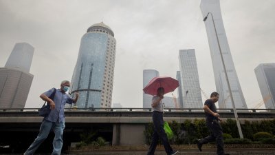 中国周一公布恢复和扩大消费20条措施。图为人们在北京中央商务区雨中散步。（路透社档案照）