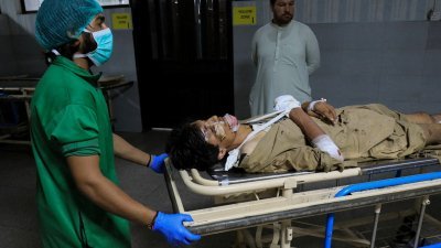在巴基斯坦白沙瓦的 Lady Reading医院，一名护理人员推著一名在开伯尔-普赫图赫瓦省巴焦尔地区发生爆炸后受伤的男子。（图取自路透社）