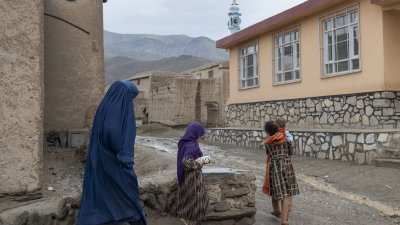 阿富汗北部小学发生两次下毒事件，近80名女孩中毒并住院治疗。图为在中部Maidan Wardak省，一名身著罩袍的妇女带著孩子走在路上。（图取自法新社） 