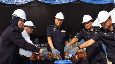 拉末（左3）等人销毁警方在执法行动中起获的走私酒精饮料。
