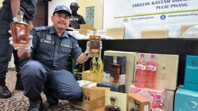 哈敏山展示槟州关税局执法员在住宅单位起获的各品牌走私烈酒。