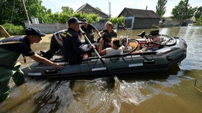 乌克兰当局说，在赫尔松俄控地区疏散受洪灾影响到居民时，一艘疏散的船只遭俄军炮击，造成3死10伤。图为乌克兰救灾人员协助灾民撤离。（图取自法新社）