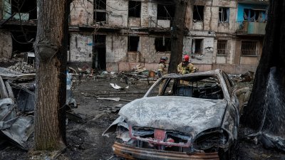 乌克兰第聂伯罗彼得罗夫斯克州克里维里赫市的一栋公寓楼，周二遭到俄罗斯导弹袭击，严重损毁，停在楼下的汽车也被烧毁。（图取自路透社）