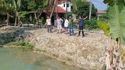 宁罗新村村长刘宝健（右起）与沙叻北新村村长和居民，视察即将兴建蓄水池的地点。