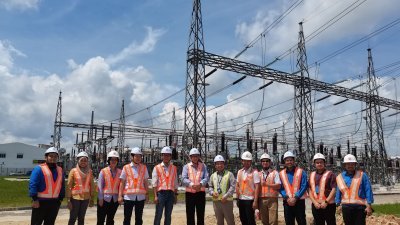 黄益豪（左4起)和陈泓宾一行人到新加望的变电站实地考察维修进展。
