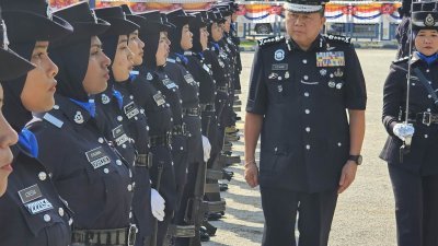 许国振（中）在官方东北县警区总部时，检视女仪仗队。