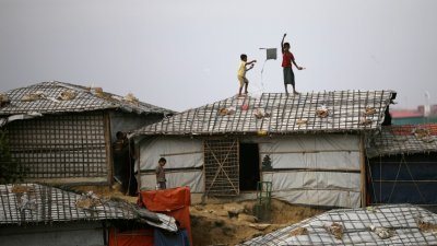 罗兴亚难民儿童在孟加拉国科克斯巴扎尔的难民营地屋顶放风筝。（图取自路透社）