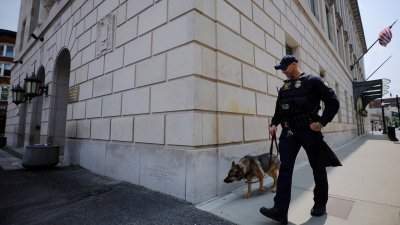 美国五角大楼情报泄漏案主嫌特谢拉受审的马萨诸塞州伍斯特的联邦法院，一名警察和警犬在法院外巡逻。（路透社档案照）