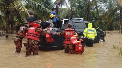 拯救人员涉水进入灾区将受困居民一一救出。