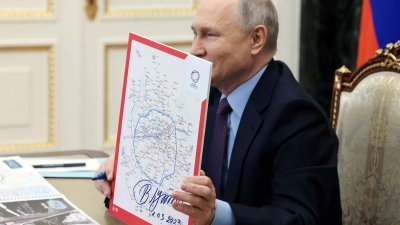 俄罗斯总统普京在莫斯科地铁大环线的路线图上签名。（图取自法新社）