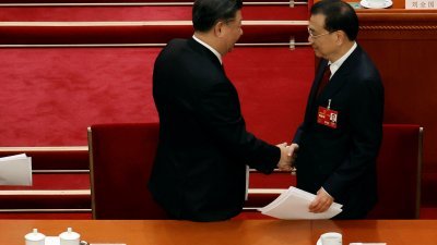周日的中国第十四届全国人民代表大会第一次会议开幕会结束时，中国国家主席习近平与总理李克强握手。（图取自路透社）