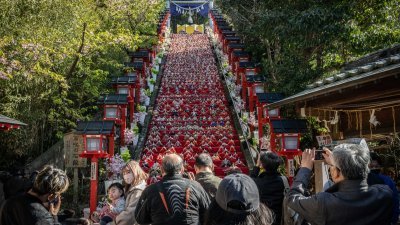 配合3月3日女儿节，上周二在日本千叶县胜浦市举行的“胜浦女儿节大人偶祭”，人们在远见岬神社石阶上展示的女儿节人偶拍照留影。（图取自法新社）
