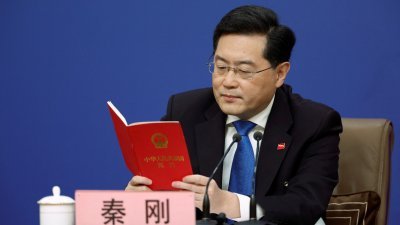 中国外长秦刚在周二的两会外长记者会上，拿出《中华人民共和国宪法》回应台湾问题。（图取自路透社）