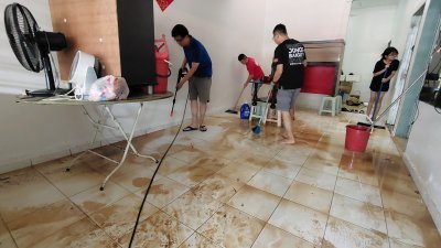 曾笳恩（左）与团队连同水灾灾黎一起清洗屋子。