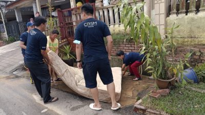 马华柔州志工团协助移出遭浸坏的床褥。