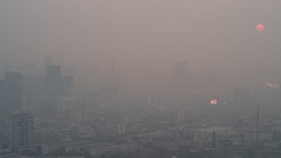 泰国首都曼谷周二清晨笼罩在一片雾霾之中，市民受促避免户外活动，外出时戴上口罩。（图取自路透社）