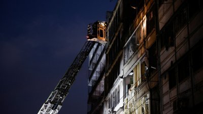 消防员和救援人员周二晚仍继续搜救，他们试图透过云梯到达发生爆炸的楼层。（图取自路透社）