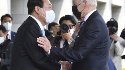 2022年5月21日，韩国总统尹锡悦（左）在首尔总统府迎接美国总统拜登。（图取自法新社档案照）