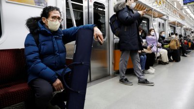 在韩国首都首尔市乘搭地铁的民众，遵从政府的防疫要求，佩戴口罩。（图取自路透社）