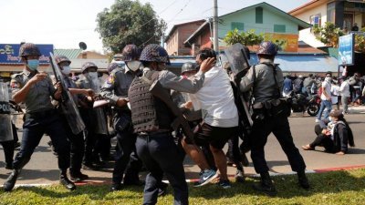 2021年2月12日，一名示威者在缅甸毛淡棉抗议军事政变期间被警察拘留。（图取自路透社档案照）