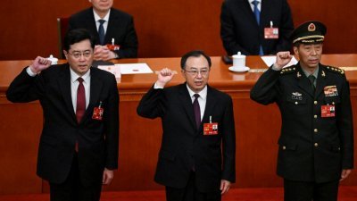 秦刚（左起）、吴政隆和李尚福当选为国务委员后，在全国人民代表大会第5次全体会议上宣誓就职。（图取自法新社）