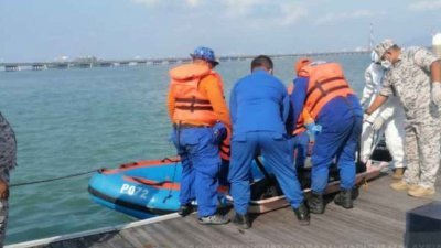 槟州海事机构人员将死者遗体打捞上岸。