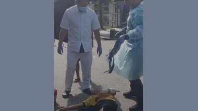 华裔电工在住家门前遭不明凶徒持斧头攻击后受伤倒地，图为医护人员在现场查看受害者伤势。（取自网络）