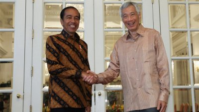 新加坡总理李显龙（右）于周四在新加坡总统府，欢迎和会晤到访的印尼总统佐科。（图取自路透社）