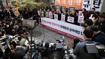 3月6日在韩国外交部前，一群活动人士抗议二战日本强征韩籍劳工受害者的第三方代赔方案。（图取自路透社）