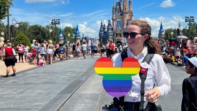 图为在美国佛罗里达州奥兰多的华特迪士尼世界魔法王国主题公园，一名摄影师手持一个同志游行的彩虹色米老鼠图案。（路透社档案照）