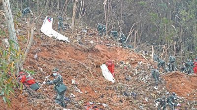 东航MU5735班机去年3月21日坠毁隔天，搜救人员在广西壮族自治区梧州市滕县的坠机现场，搜寻客机黑箱。（图取自新华社/路透社）