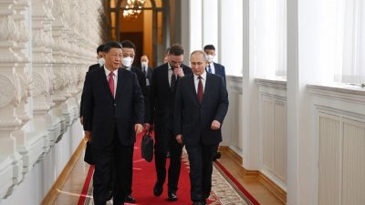 俄罗斯总统普京与国事访问的中国国家主席习近平，并肩走在克里姆林宫。（图取自俄罗斯卫星通讯社/法新社）