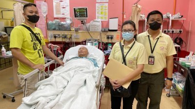 71岁退休中医师温荏昌脑中风，尚缺4万5000令吉救命，儿子温钧卫（左）急盼大众的捐助。
