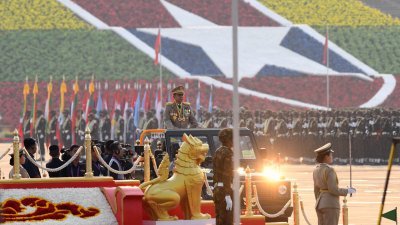 缅甸国防军总司令敏昂莱周一站在车里，出席在首都内比都举行的年度军人节阅兵仪式。（图取自法新社）
