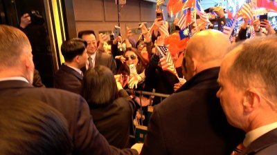 台湾总统蔡英文（背对镜头握手者）出访友邦，周三过境美国纽约，在下榻的乐天纽约皇宫饭店外与在美台人握手。（图取自中央社）