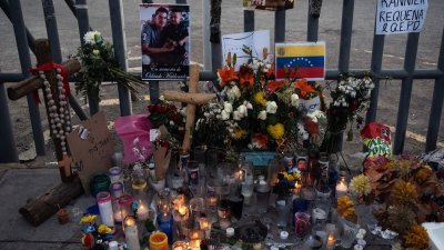 墨西哥奇瓦瓦州华雷斯城周一失火的移民中心外，摆放了祭坛纪念39名丧生的移民。（图取自法新社）