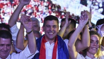 巴拉圭执政党红党的总统候选人佩纳（中）与妻子德佩亚（右），还有前总统卡斯特当地时间周日晚在亚松森庆祝赢得大选。（图取自法新社）
