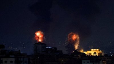 以色列周二凌晨突然对加沙地带发动空袭，导致3名“伊斯兰圣战组织”指挥官和10名平民丧生，爆炸照亮了加沙地带的天空。（图取自路透社）