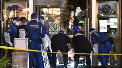 日本东京都银座购物区的名表店周一遭抢劫后，警方在现场展开调查。（图取自法新社）